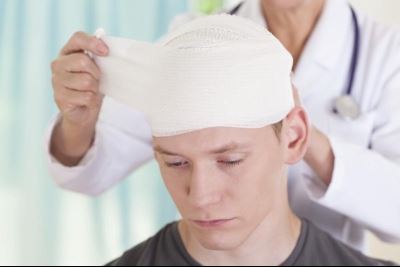 Doctor removing head bandage